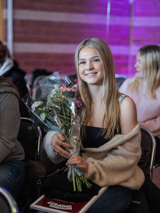 Smilla, en av vinnarna, med blombukett och diplom.